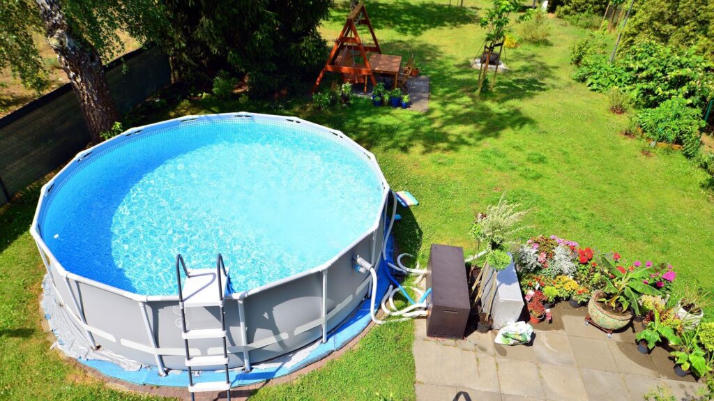 Runder Frame-Pool mit Leiter im Garten, von oben gesehen