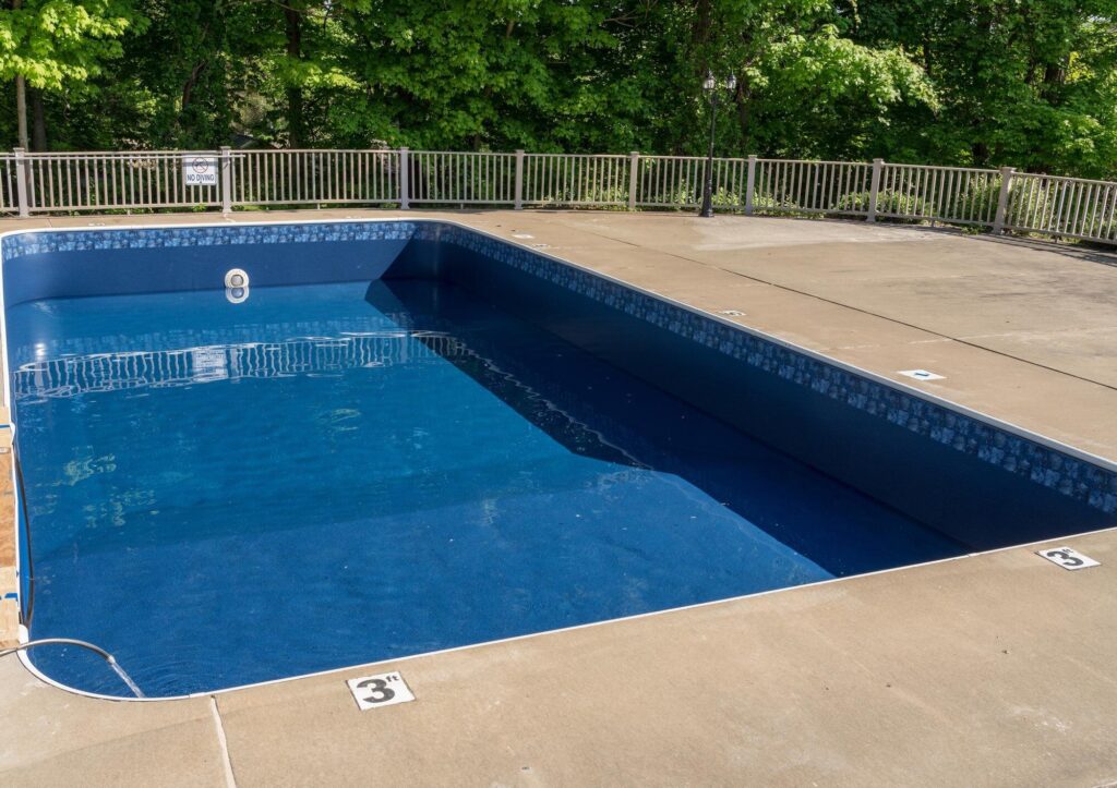 Einbaupool mit dunkelblauer Folie und Mosaik-Bordüre, frisch befüllt