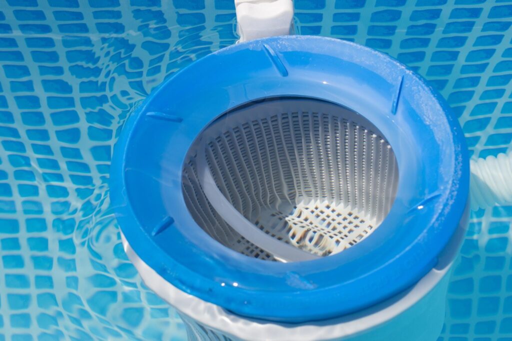 Nahaufnahme eines Skimmerkorbs mit feinem Lochmuster im Poolwasser