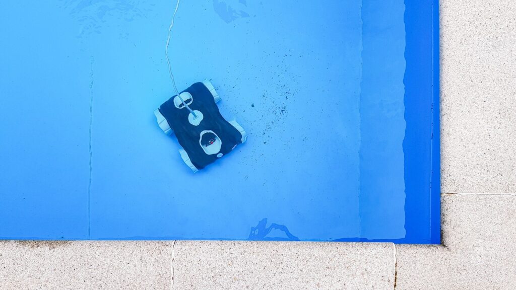 Poolroboter am Beckenboden in der Ecke eines Pools, senkrecht von oben